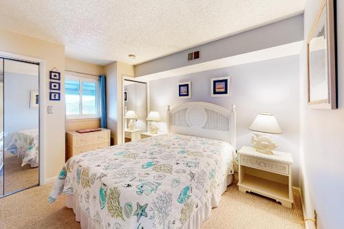 a bedroom with a white bed and a mirror at Hidden Harbour 312C in Ocean City