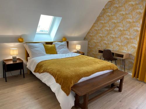 a bedroom with a large bed with a yellow blanket at Chez Catherine et Laurent in Ploemeur