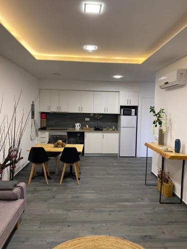 a kitchen with white cabinets and a table with chairs at Garden Apartment Dona Amélia in Abrantes