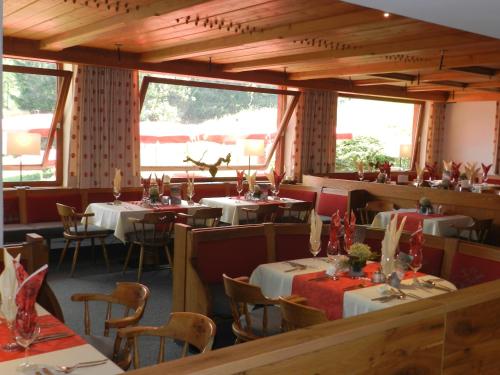 a restaurant with tables and chairs in a room at Alpengasthof Hotel Schwand in Oberstdorf