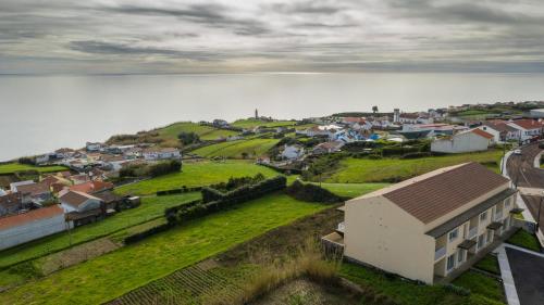 a small town with a house on a hill next to the water at GarçaView in Vila Franca do Campo