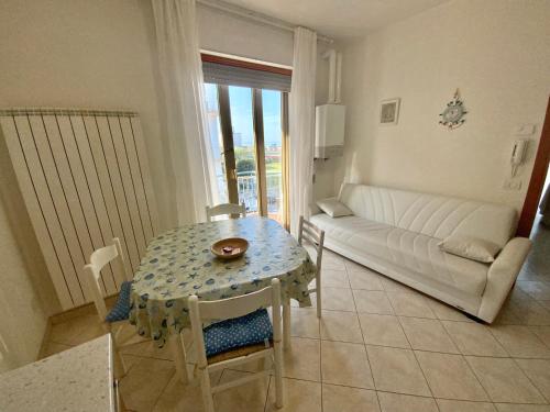 uma sala de estar com uma mesa e um sofá em Bella Vista apartment em Chioggia