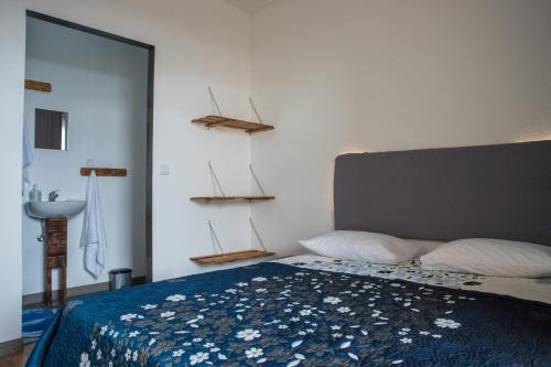 a bedroom with a bed with a blue comforter at GarçaView in Vila Franca do Campo