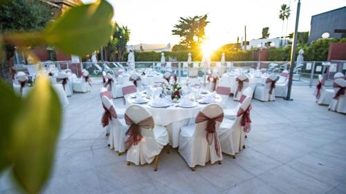 a group of tables and chairs with white table cloths at Alborán Algeciras in Algeciras