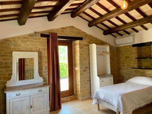 sypialnia z łóżkiem, lustrem i oknem w obiekcie agriturismo borgo del ginepro w mieście Castiglione Messer Raimondo