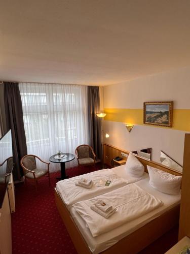 ein Hotelzimmer mit einem Bett und einem Tisch in der Unterkunft Hotel Poseidon in Kühlungsborn