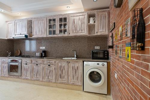 una cucina con lavatrice e un muro di mattoni di Luxury two bedrooms apartment - Best Location a Rabat