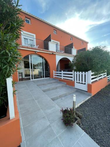 an orange building with a walkway in front of it at Hôtel Athéna in Agde