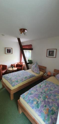 ein Schlafzimmer mit zwei Betten und ein Wohnzimmer in der Unterkunft Ferienwohnung Altenbrak Haus Wilde in Thale