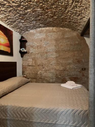 a bed in a room with a brick wall at Casa Ciccio in Isola delle Femmine