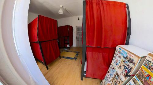 una habitación con cortinas rojas y una habitación con suelo de madera en M2Students Hostel, en Oporto