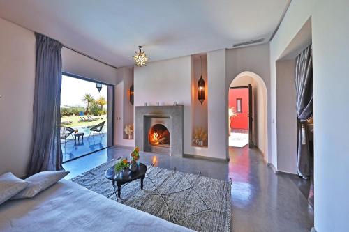 a living room with a fireplace and a bed at DAR NOUJOUM in Marrakech