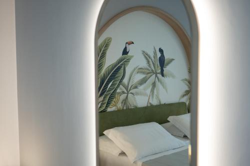 Cette chambre comprend un lit et une fresque murale représentant des oiseaux. dans l'établissement Ingrid Rooms Tropea, à Tropea