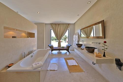 a large bathroom with a tub and a sink at DAR NOUJOUM in Marrakech