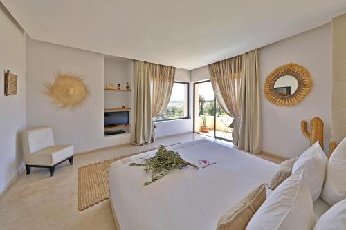 Habitación blanca grande con cama grande y sofá en DAR NOUJOUM en Marrakech