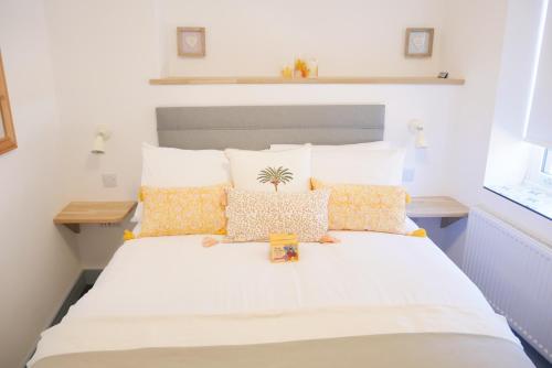 a bedroom with a large white bed with yellow pillows at Sunset View, 2 bedrooms in the heart of Holt with parking in Holt
