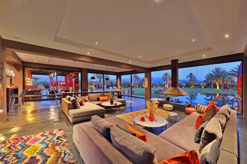 a large living room with couches and a large window at DAR NOUJOUM in Marrakech