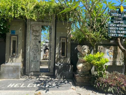 a statue in front of a building with a door at The Niti Hut's Lembongan in Nusa Lembongan