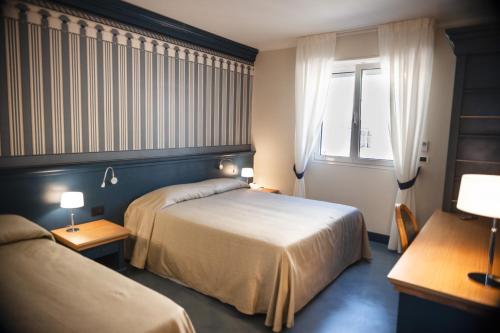 a hotel room with two beds and a window at MH HOTEL VARAZZE in Varazze