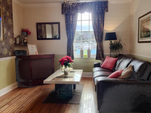 a living room with a couch and a table and a window at The Warwick in Weymouth