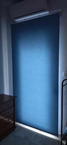 a blue wall in a room with a dresser at Ilio Socrates in Skala Marion