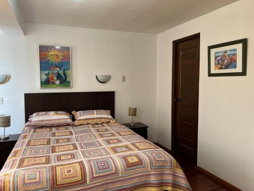 1 dormitorio con 1 cama grande y 2 almohadas en Apartamento La Cusqueñita, en Cusco