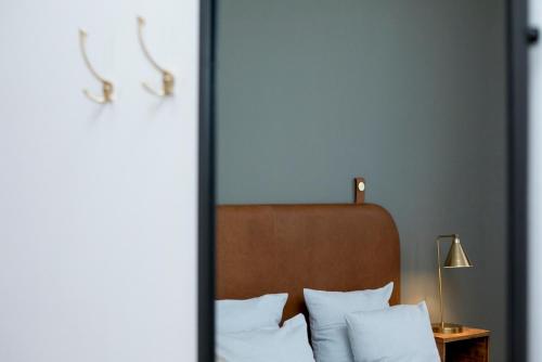 a bedroom with a bed with white pillows and a headboard at Hotel VANDret in Løkken