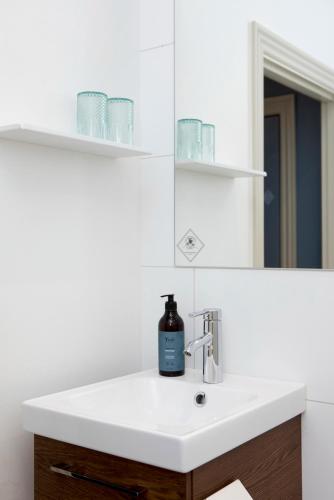 a bathroom sink with a bottle of soap on it at Hotel VANDret in Løkken