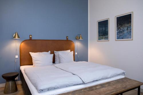 a bedroom with a large bed with white sheets at Hotel VANDret in Løkken