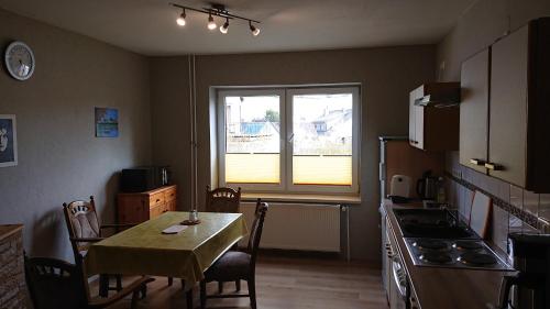 een keuken met een tafel en een tafel en een raam bij Ferienwohnung Angelburg - Marburg Biedenkopf mit Balkon und Badewanne in Gönnern