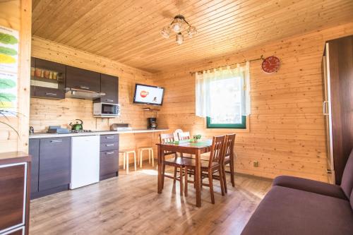 uma cozinha com mesa e cadeiras num quarto em Zielone Domki Morze & Jezioro em Ustronie Morskie