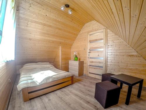 um quarto com uma cama num quarto de madeira em Zielone Domki Morze & Jezioro em Ustronie Morskie
