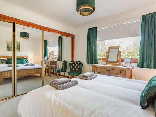 a bedroom with two beds and a mirror at Craigievar in Cruden Bay