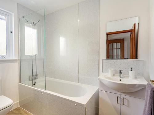 a white bathroom with a sink and a shower at Craigievar in Cruden Bay