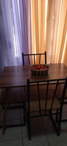 a bowl of fruit on a wooden table with a chair at Ilio Socrates in Skala Marion