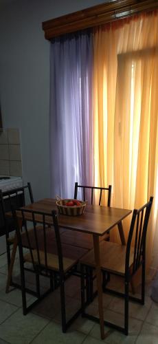 a wooden table with chairs and a bowl on top at Ilio Socrates in Skala Marion