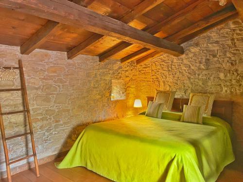 a bedroom with a green bed with two chairs at Mulino del Lentino in Nibbiano