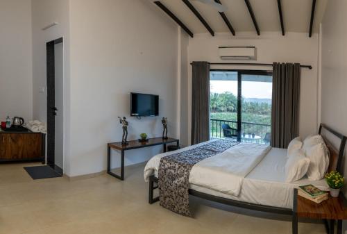 um quarto com uma cama e uma varanda em The Green Estate Resort em Nashik