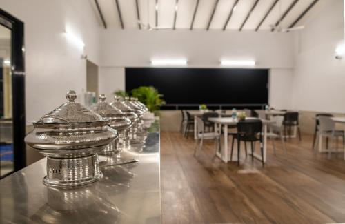 a row of silver tables and chairs in a room at The Green Estate Resort in Nashik