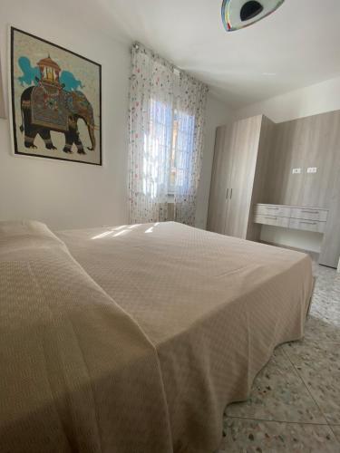 una camera con un grande letto con una foto di un elefante di Casa Antonella a Porto Azzurro