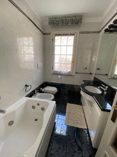 a bathroom with a tub and a sink and a toilet at Casa Antonella in Porto Azzurro