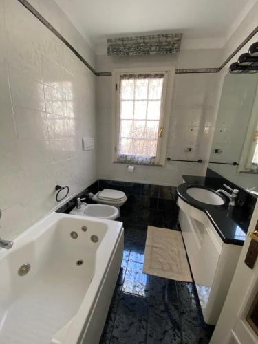 bagno con vasca, lavandino e servizi igienici di Casa Antonella a Porto Azzurro