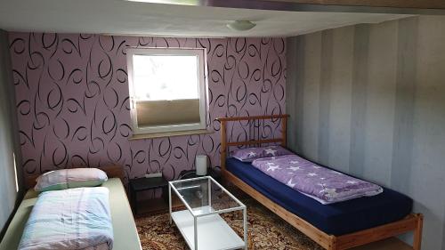a small bedroom with two beds and a window at Ferienwohnung Gönnern - Marburg Biedenkopf mit 5 Zimmer - 2 Badezimmer in Gönnern