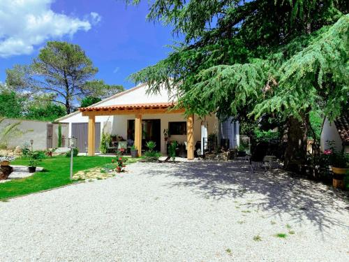 uma casa com uma entrada de cascalho em frente em Gîte les 2 cèdres em Cardet