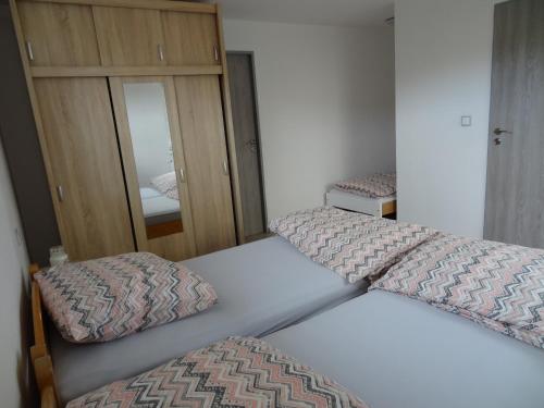 a bedroom with two beds and a mirror at Apartmán Karovi in Deštné v Orlických horách