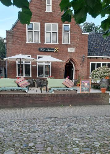 a brick building with beds and umbrellas in front of it at Hotel Stedswal in Sloten