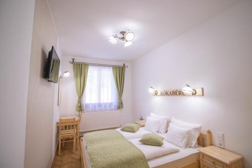 a bedroom with a bed and a window at Rókabérc Vadászház Hotel in Erdőbénye