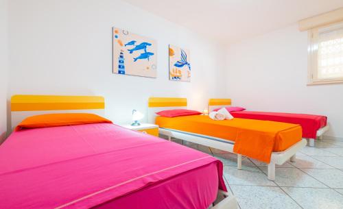 duas camas com capas coloridas num quarto em Dimora Giusy Vista Mare Pescoluse em Marina di Pescoluse