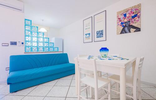uma sala de estar com uma mesa e um sofá azul em Dimora Giusy Vista Mare Pescoluse em Marina di Pescoluse