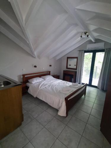 a bedroom with a large bed and a window at Villa Lithitsa in Parga